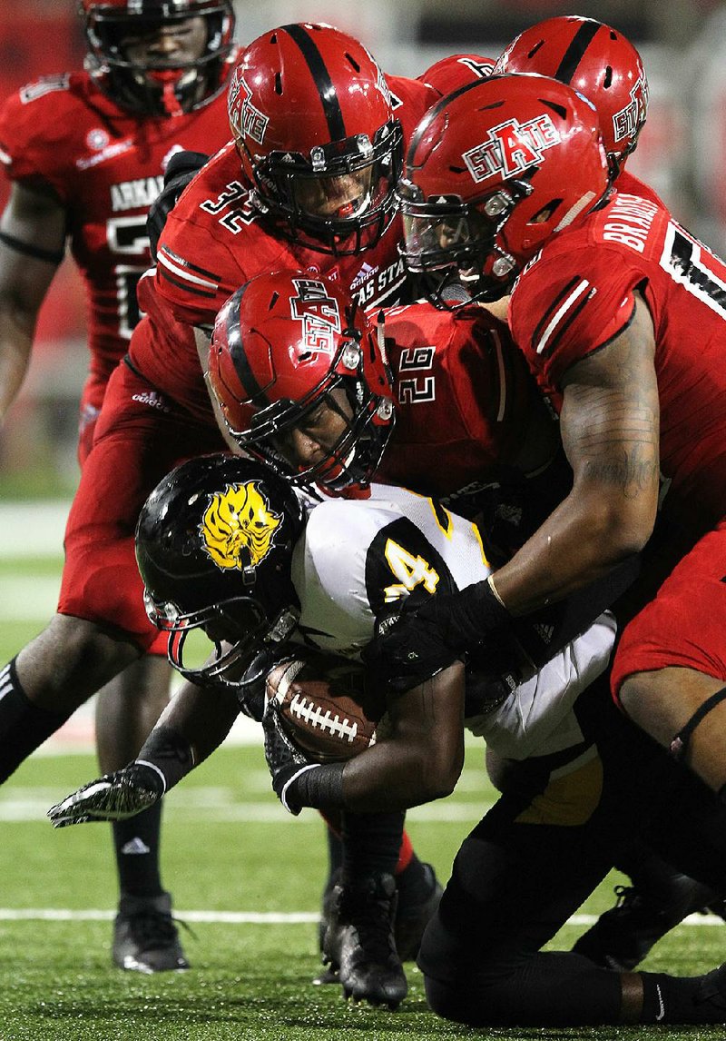 Arkansas-Pine Bluff running back Tryvarious Cole (24) is tackled for a loss by Arkansas Tech linebackers Trent Ellis-Brewer (26) and Tajhea Chambers (32) during the third quarter of ASU’s 38-3 win Saturday.