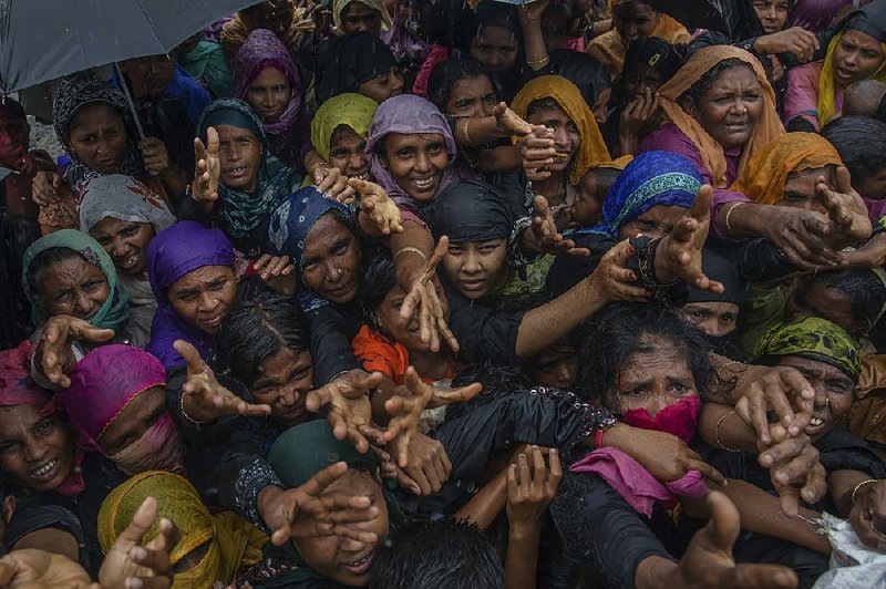 Rohingya Muslim women clamor Sunday for sanitary products from aid agencies near their refugee camp in Bangladesh.