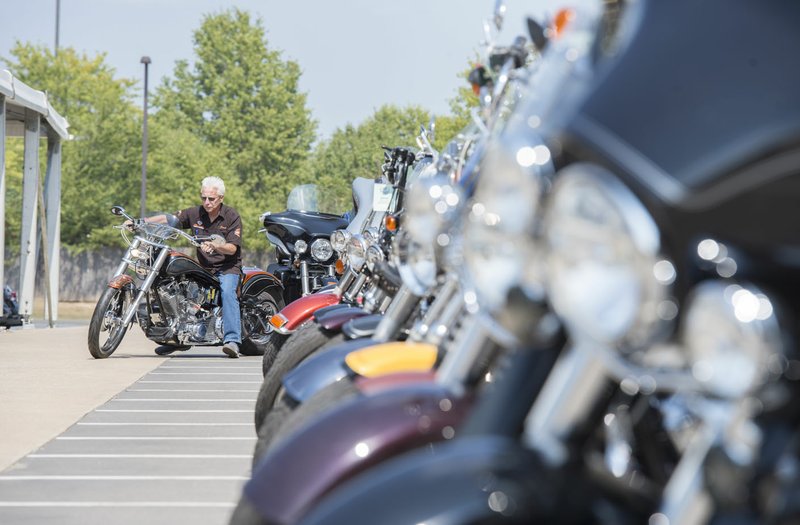 Frank Hardman, general sales manager, prepares to ride past a row of motorcycles for sale Saturday at Pig Trail Harley-Davidson in Rogers. The business has had its own event during Bikes, Blues & BBQ for a decade. An extra 100 employees will be brought in for the event, said Frank Hardman, general sales manager. In addition, he said the business expects to sell about 200 motorcycles through the event.