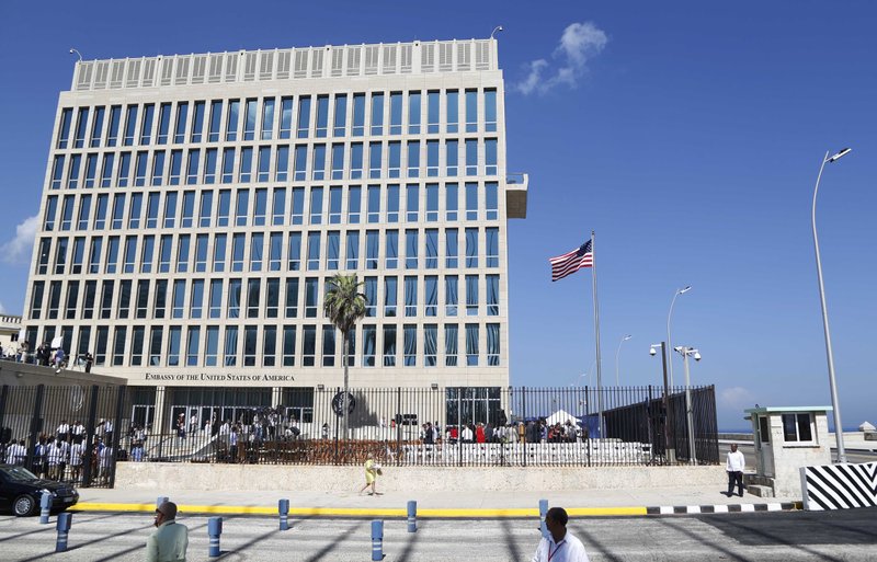 In this Aug. 14, 2015, file photo, a U.S. flag flies at the U.S. embassy in Havana, Cuba. U.S. investigators are chasing many theories about what's harming American diplomats in Cuba, including a sonic attack, electromagnetic weapon or flawed spying device. 