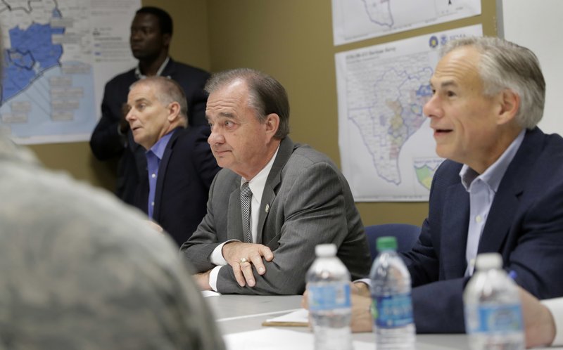 In this Sept. 14, 2017 photo, Texas Gov. Greg Abbott, center, and Commissioner John Sharp, seated second from left, receive a briefing on Hurricane Harvey recovery efforts at the new FEMA Joint Field Office, in Austin, Texas. Sharp, the recovery czar over Texas' rebuild after Harvey, says his new job is &quot;future-proofing&quot; for the next disaster.