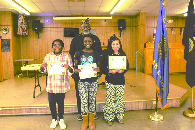 War on drugs: Three sixth grade students from Washington Middle School (from left) Diana Obiozo, Anastasia Montgomery and Maria Ruiz, pose with American Legion Adjutant Deacon Jones on Tuesday, Sept. 12 with their awards. The students decorated posters for a War on Drugs awareness contest and Obiozo, Montgomery and Ruiz's posters were chosen by the American Legion Post 10 members as first, second and third place for best poster.  
