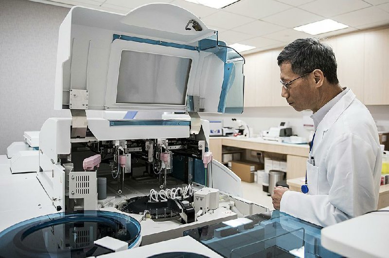 A technician inspects a blood analyzer in the Roche Holding AG diagnostic lab in Hong Kong in this file photo. Of the seven biosimilar drugs the FDA has cleared since 2015, including a version of Roche’s Avastin cancer treatment, only three are available for sale.