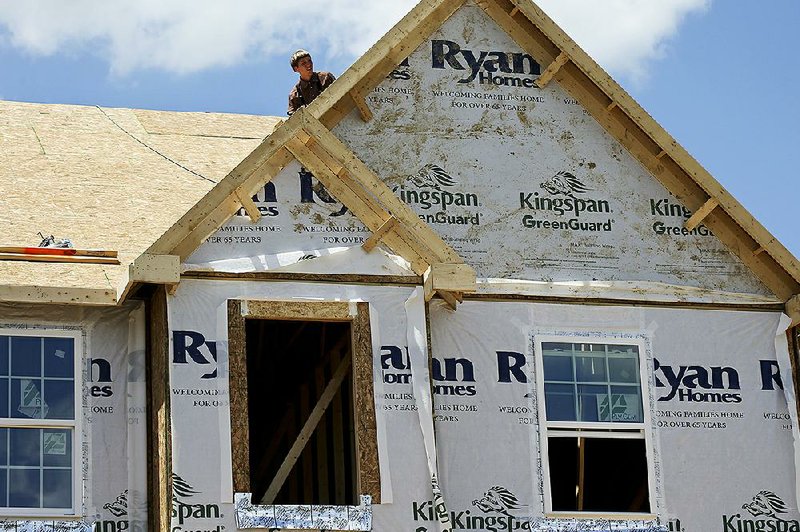 Builders work on the roof of a house under construction in Butler County, Pa., in June. The National  Association of Home Builders/Wells Fargo said its homebuilder sentiment index released Monday fell for September compared with August.