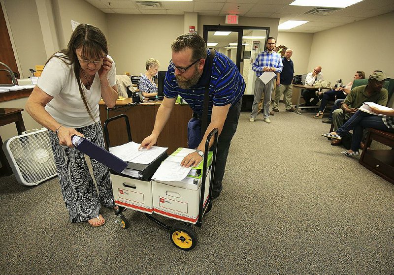 Attorney Dan Roda turns in applications for medical-marijuana business clients to Maggie Costly of Alcoholic Beverage Control on Monday, which was the deadline to submit applications to grow and sell medical marijuana. A state commission will decide the recipients by year’s end.