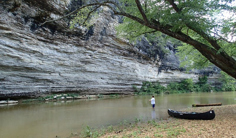 Bluffs are numerous along the War Eagle River as it meanders through forest and fields. Alan Bland of Rogers fishes during a lunch stop last month.