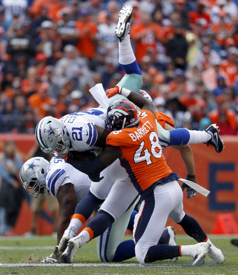 The Associated Press TAKING A HIT: Dallas Cowboys running back Ezekiel Elliott (21) is hit by Denver Broncos outside linebacker Shaquil Barrett (48) during the first half of Sunday's game in Denver.