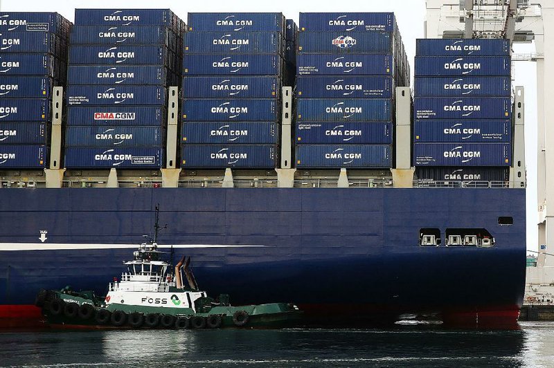 A Foss Maritime tugboat nudges the container ship CMA CGM Benjamin Franklin into place at Seattle’s Terminal 18 in this file photo. A broad measure of the U.S. trade deficit rose to the highest level in more than eight years this spring. 