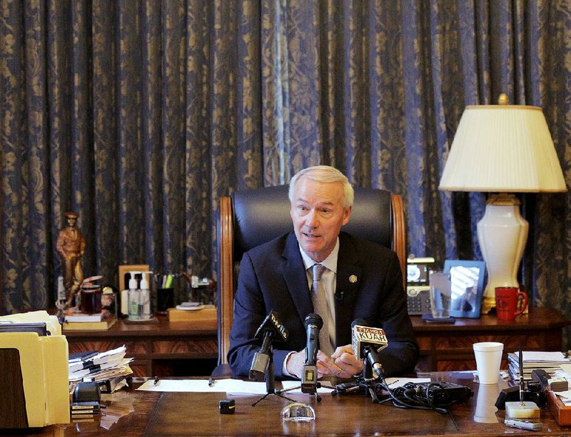 Gov. Asa Hutchinson talks with reporters during a news conference in his office Tuesday afternoon at the state Capitol in Little Rock. 