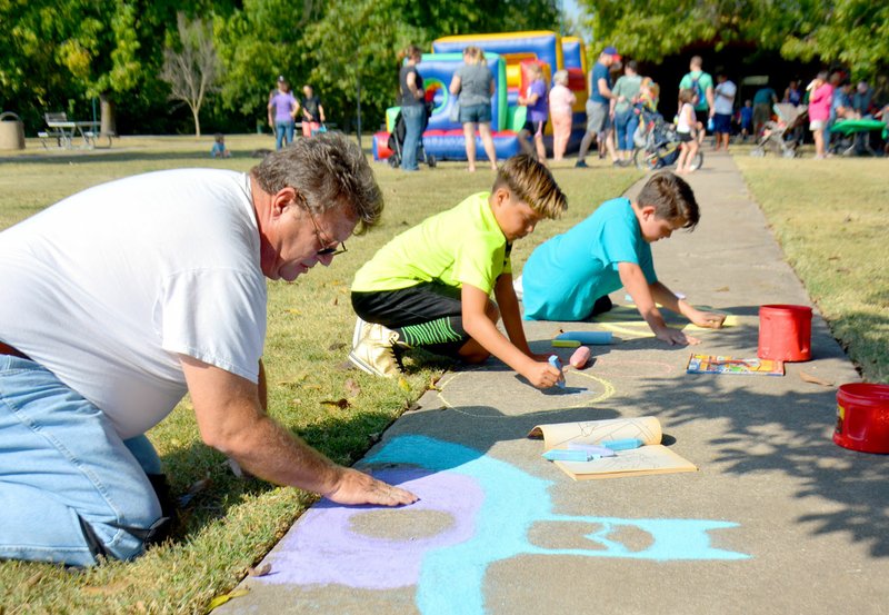 Janelle Jessen/Herald-Leader Artist Michael Kelly helped children create chalk-art and created some artwork of his own.