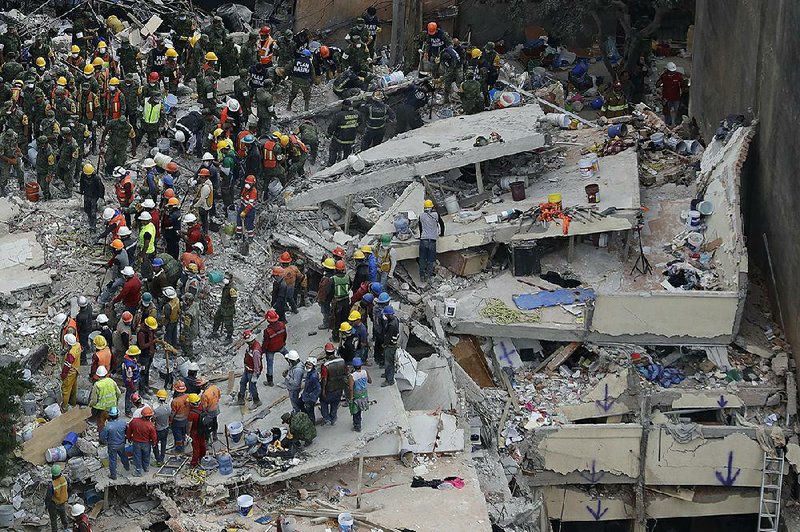 Rescue workers search for people trapped inside a collapsed building Wednesday in the Del Valle area of Mexico City.