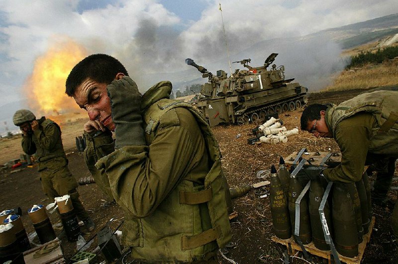 Israeli soldiers cover their ears as an artillery unit fires shells towards southern Lebanon from a position near Kiryat Shmona in northern Israel, near the border with Lebanon, in this July 21, 2006, file photo. With President Bashar Assad seemingly poised to survive the Syrian civil war, Israeli leaders are growing nervous about the intentions of his Iranian patrons and their emerging corridor of influence across the region.  