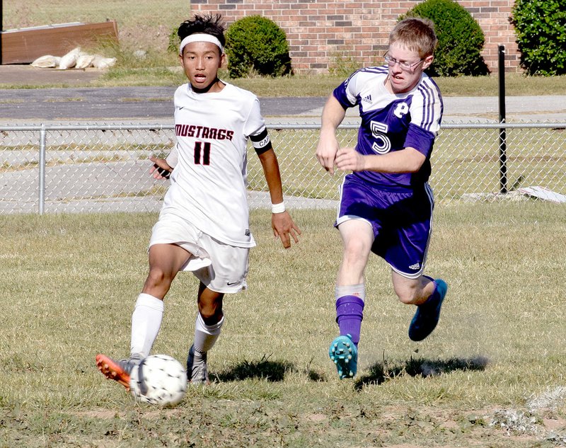 Photo by Rick Peck McDonald County&#8217;s Eh Doh Say gets past a Pittsburg defender during the Purple Dragons&#8217; 2-1 win on Sept. 11 at MCHS.