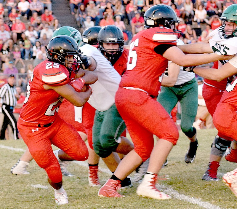 Photo by Rick Peck McDonald County running back Isrrael De Santiago runs behind offensive lineman Will Gordon for some of his 95 rushing yards in the Mustangs&#8217; 343-21 loss to Mount Vernon on Sept. 15 at MCHS.
