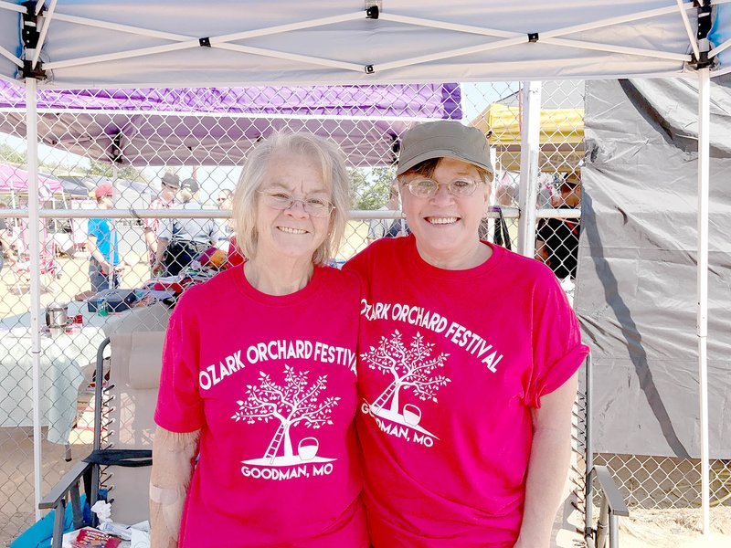 Sally Carroll/McDonald County Press Goodman Alderwoman Alice Kezar, left, and Paula Brody take a moment to pause during volunteering at the Ozark Orchard Festival in Goodman.