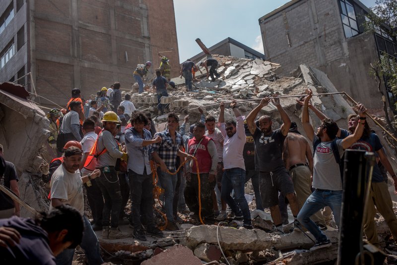 People remove debris from a collapsed building following an earthquake in Mexico City on Sept. 19, 2017. MUST CREDIT: Bloomberg photo by Alejandro Cegarra.