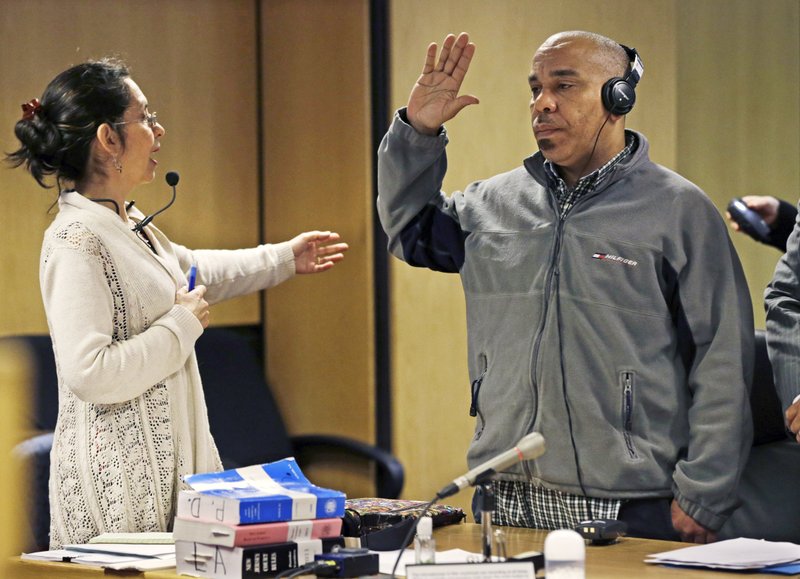 In this April 1, 2013, file photo, Pedro Quezada, right, winner of a $338 million Powerball jackpot, swears to tell the truth through an interpreter during a hearing about child support payments for three of his five children in state Superior Court in Paterson, N.J. Quezada, of Wayne, N.J., has been charged with sexual assault and endangering the welfare of a child, Passaic County Prosecutor Camelia Valdes said Wednesday, Sept. 20, 2017. The prosecutor said the child was between 11 and 14 when the assaults occurred, and there don't appear to be any other victims.
