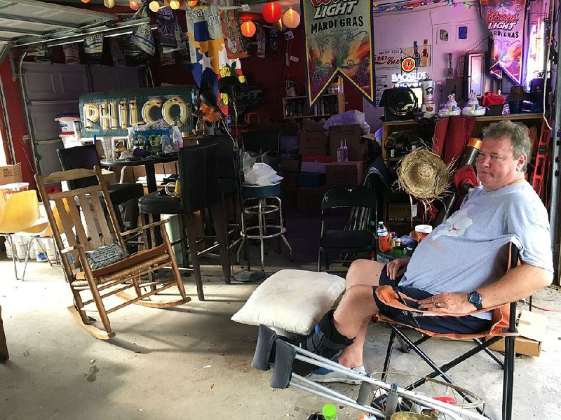 Bob Cantrell sits in his garage Wednesday surrounded by belongings salvaged after Hurricane Harvey’s !ooding in Houston. He said raising property taxes is “not a good idea.”  