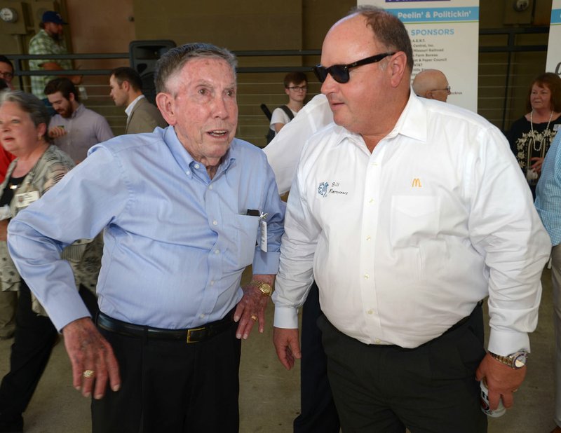 FILE -- Bobby Hopper (left), former member of the Arkansas Highway Commission, speaks with Bill Mathews, co-owner of McDonald’s restaurants in Northwest Arkansas, during the annual Springdale Chamber of Commerce’s “Chickin, Peelin’ and Politickin’” event at Walter Turnbow Park at Shiloh Square in downtown Springdale in September 2017.