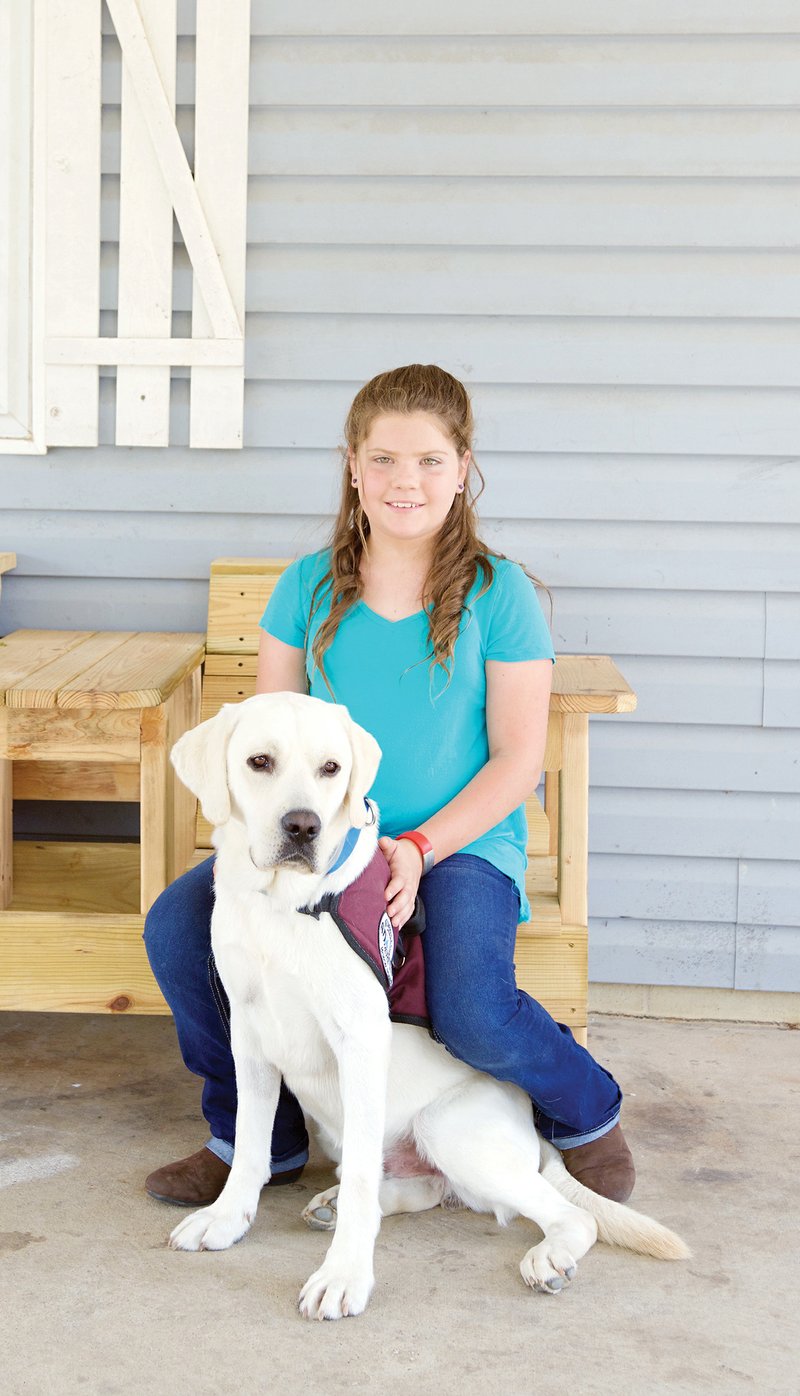 A Type 1 diabetic Sunnie Simpson, 10, bonds with her new diabetic-alert dog, Bentley, whom she recieved recently after a $25,000 fundraising campaign conducted by her mother. Bentley smells the differences in Sunnie’s blood-sugar levels and taps either Sunnie or her mother on the leg with his paw to alert them.