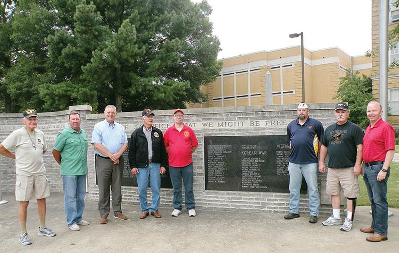 Faulkner County Judge Jim Baker, third from left, invites other veterans to pose for a photograph in front of the Faulkner County Veterans Memorial in Conway that honors the county’s war dead. Joining Baker are James Wofford, from left, Greenbrier Mayor Sammy Joe Hartwick, Faulkner County Veterans Service Officer Albert Meyer, Donnie Hay, Veterans of Foreign Wars Post 2259 Commander Chris Ray, Bill Howell and Faulkner County Administrator Tom Anderson.