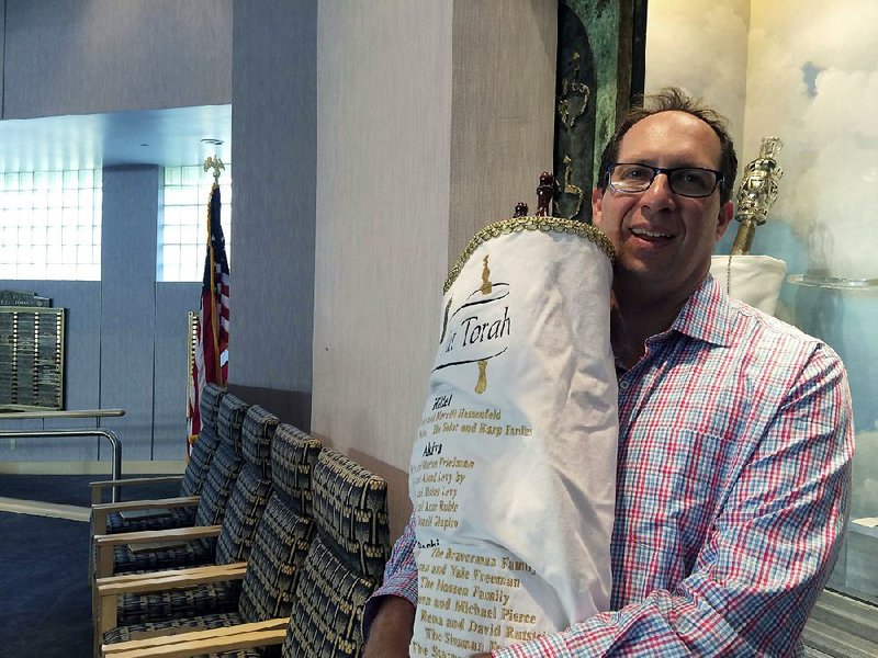 Rabbi Adam Miller of Temple Shalom in Naples, Fla., holds the Torah he took to Memphis to protect it from Hurricane Irma. Miller has rewritten his Rosh Hashana sermon to reflect the damage done to southwest Florida by the storm. 