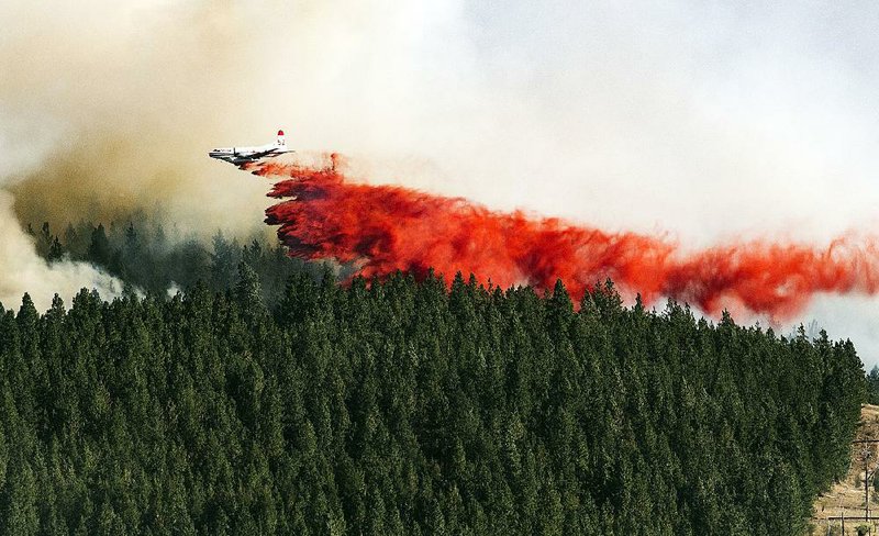 A plane drops fire retardant in Spokane, Wash., in August 2016. It’s hoped agreements between the U.S. Forest Service and Idaho regarding logging and forest maintenance on federal lands will become models for other Western states. 