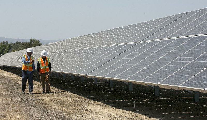 Workers inspect panels at Pacific Gas and Electric’s solar plant in Dixon, Calif., in August. Cheap imports have led to a boom in the U.S. solar industry. 