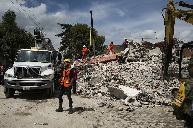 Rescuers on Friday search the rubble of building in San Gregorio Atlapulco, Mexico, that collapsed during Tuesday’s earthquake. 
