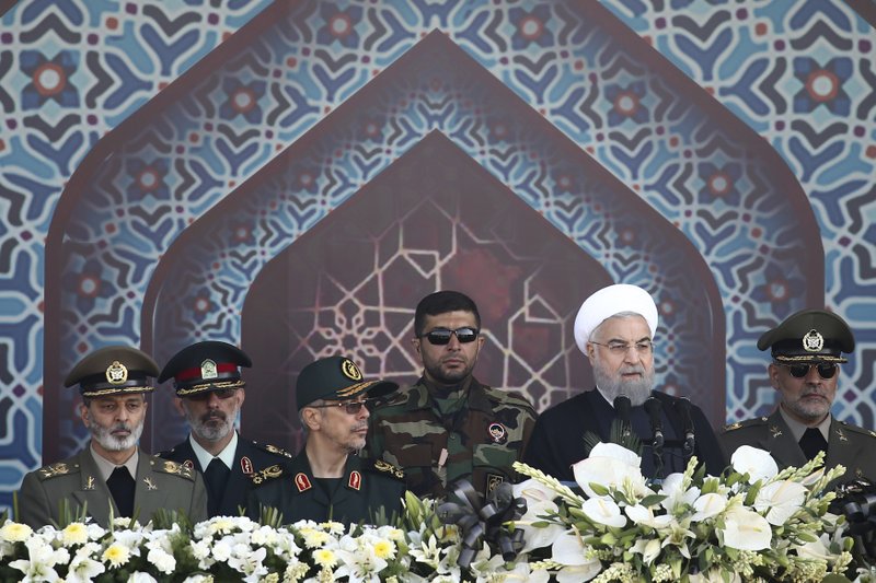 Iran's President Hassan Rouhani, second right, speaks at a military parade marking the 37th anniversary of Iraq's 1980 invasion of Iran, in front of the shrine of the late revolutionary founder, Ayatollah Khomeini, just outside Tehran, Iran, Friday, Sept. 22, 2017.  (AP Photo/Ebrahim Noroozi)