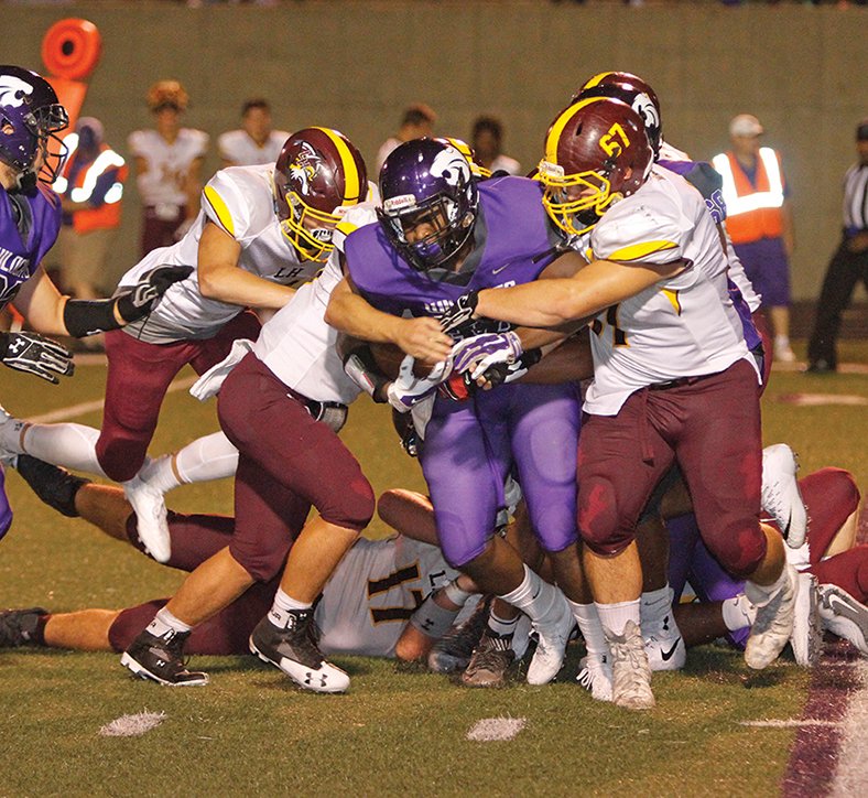 Terrance Armstard/News-Times El Dorado's Richard Kesee tries to fight through a pack of Lake Hamilton defenders. Kesee rushed for 96 yards and two touchdowns Friday as the unbeaten Wildcats turned back the Wolves 35-13 at Memorial Stadium.