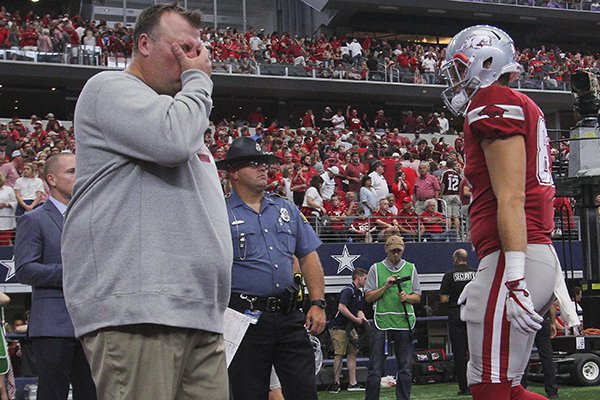 Arkansas coach Bret Bielema, left, waits for players to leave the field following a 50-43 overtime loss to Texas A&M on Saturday, Sept. 23, 2017, in Arlington, Texas. 