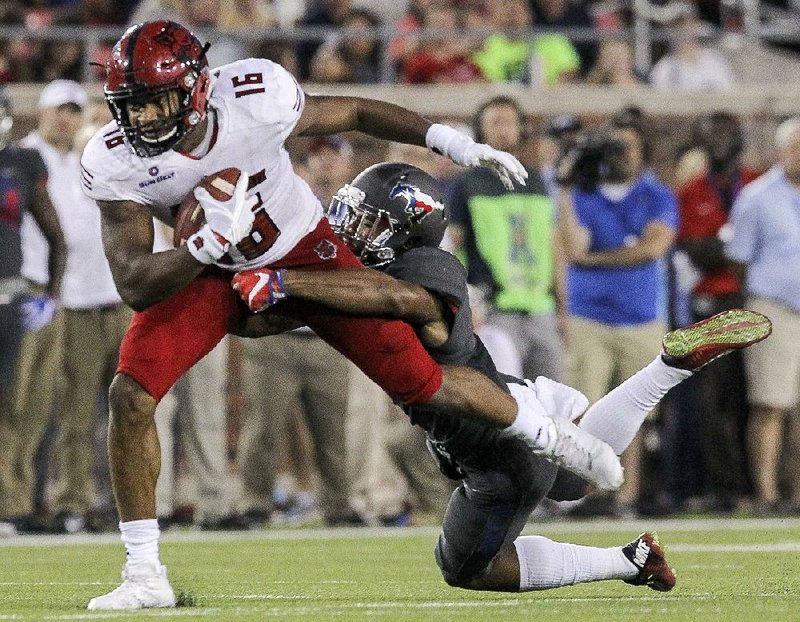 Arkansas State’s Blake Mack is tackled by SMU safety Rodney Clemons during the first half of Saturday night’s game in Dallas. ASU led 14-10 after one quarter, but SMU took over after that.