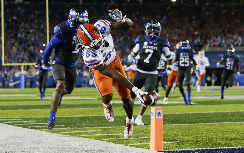 Florida wide receiver Tyrie Cleveland stretches for the goal line in front of Kentucky cornerback Derrick Baity (left) and safety Mike Edwards to score a touchdown Saturday during the No. 20 Gators’ 28-27 victory over the Wildcats in Lexington, Ky. 