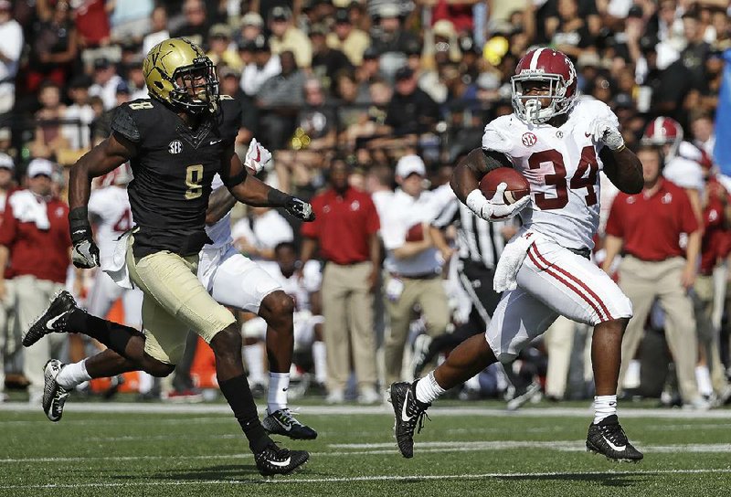 Alabama running back Damien Harris (34) runs 61 yards for a touchdown ahead of Vanderbilt cornerback Joejuan Williams during the top-ranked Crimson Tide’s 59-0 victory over the Commodores on Saturday in Nashville, Tenn. Harris finished with 151 yards and 3 touchdowns on 12 carries for the Crimson Tide.   