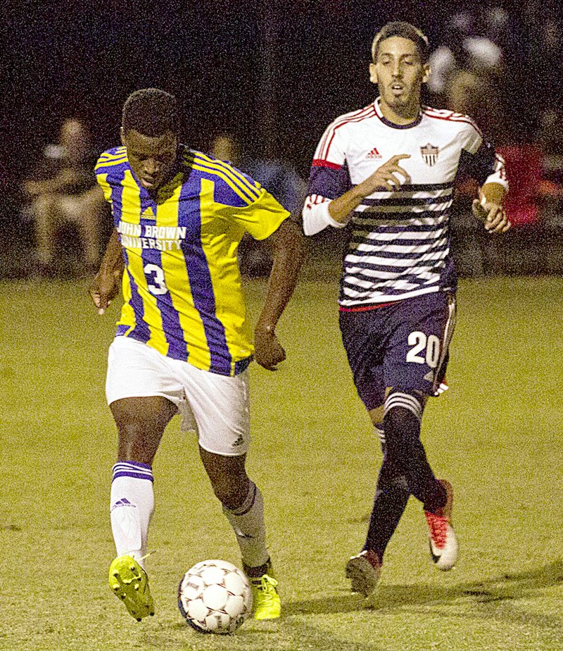 Photo courtesy of JBU Sports Information John Brown junior Giovani Bejarano, left, keeps the ball away from Oklahoma Wesleyan&#8217;s Daniel Cordeiro during Tuesday&#8217;s match in Bartlesville, Okla. The Golden Eagles scored two late goals to upset No. 1-ranked OKWU 2-1.