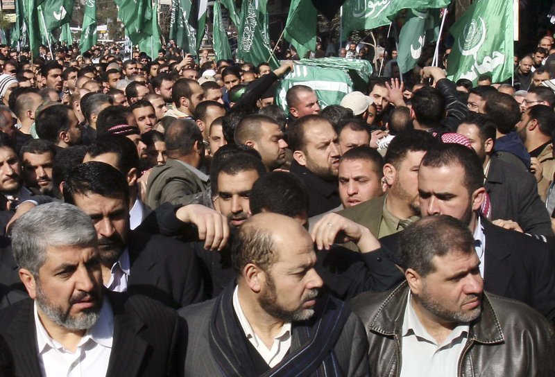 In this Jan. 29, 2010 file photo, Hamas leader Khaled Mashaal, bottom left, marches as mourners carry the coffin of Mahmoud al-Mabhouh, one of the founders of Hamas' military wing, during his funeral procession at the Palestinian refugee camp of Yarmouk, near Damascus, Syria. 