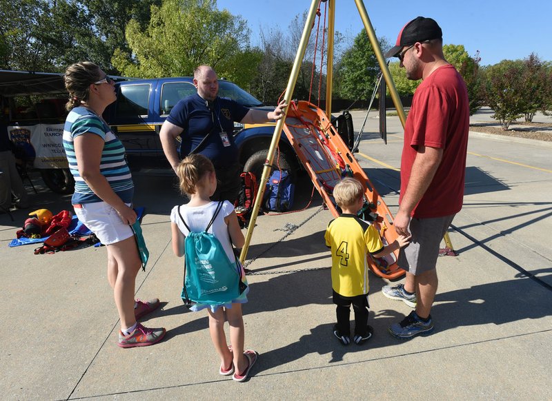 NWA Democrat-Gazette/FLIP PUTTHOFF William Crocker with Benton County’s Search and Rescue team explains rescue techniques Saturday at the Emergency Preparedness Fair in Bentonville. Aslee Bechdoldt (left) and Rodney Bechdoldt of Bentonville listen with their children Brooklyn, 6 and Lincoln, 2.