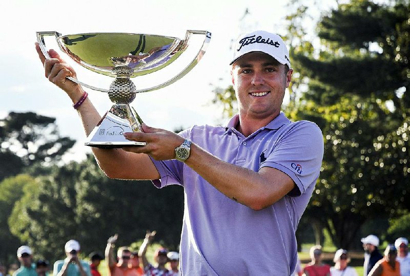 Justin Thomas holds the trophy after winning the Fedex Cup after the Tour Championship golf tournament at East Lake Golf Club in Atlanta, Sunday, Sept. 24, 2017, in Atlanta. 