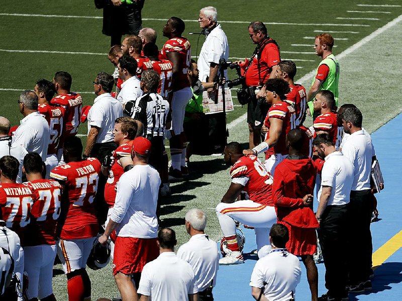 Members of the Kansas City Chiefs sit in protest during the National Anthem before Sunday’s game against the Los Angeles Chargers. Protests against comments made by President Donald Trump spread throughout the league.