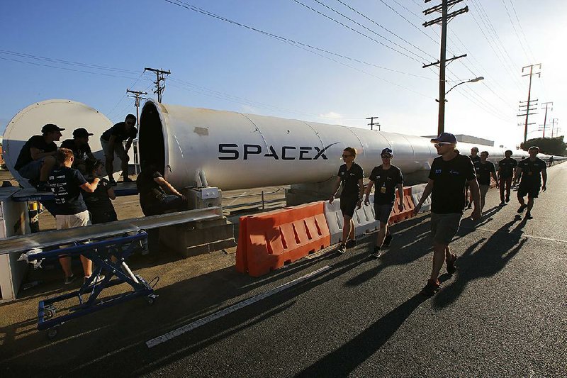 Members of the WARR team from Technische Universitat Munchen walk to the end of the SpaceX’s Hyperloop track to retrieve their winning pod in Hawthorne, Calif., last month.