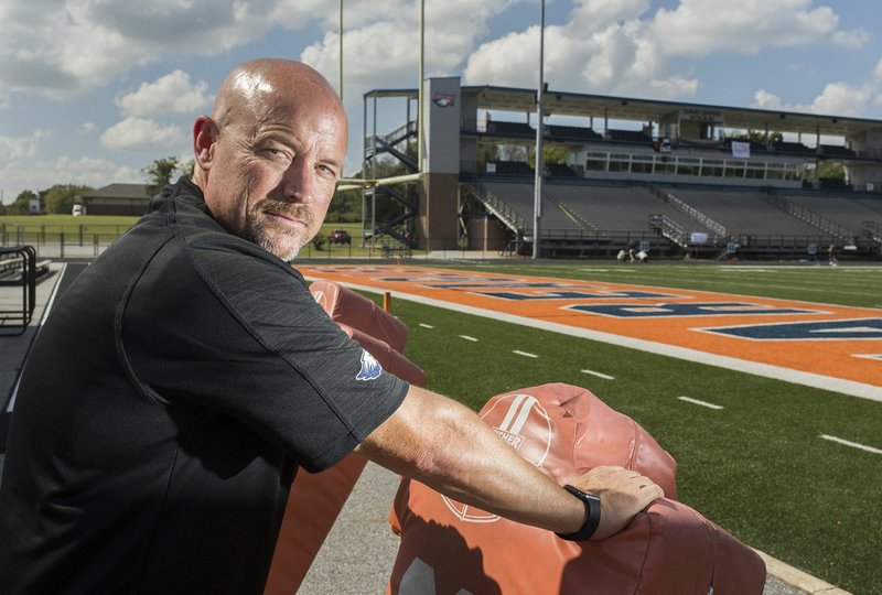 Keith Kilgore poses Friday for a portrait at the Heritage High School’s David Gates Stadium in Rogers. Kilgore is the new athletic director for the Rogers School District. “I want our coaches and athletes to understand we can lead the pack,” he said.