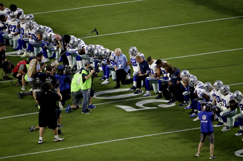 The Dallas Cowboys, led by owner Jerry Jones, center, take a knee prior to the national anthem prior to an NFL football game against the Arizona Cardinals, Monday, Sept. 25, 2017, in Glendale, Ariz. (AP Photo/Matt York)