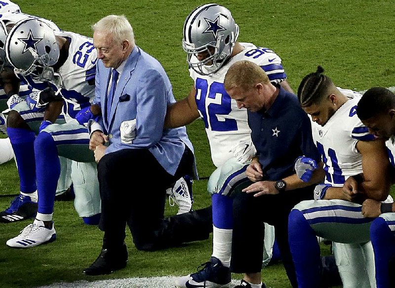 Dallas Cowboys owner Jerry Jones and head Coach Jason Garrett join the team in kneeling on the field at University of Phoenix Stadium before the national anthem preceding Monday night’s game against the Arizona Cardinals in Glendale, Ariz.