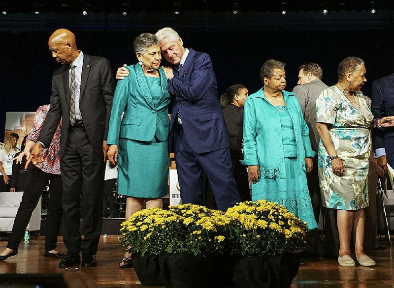 Former President Bill Clinton embraces Carlotta Walls LaNier, one of the Little Rock Nine, at the end of the commemoration ceremony Monday on the 60th anniversary of desegregation at Little Rock Central High School. Another Little Rock Nine member onstage was Elizabeth Eckford (right).