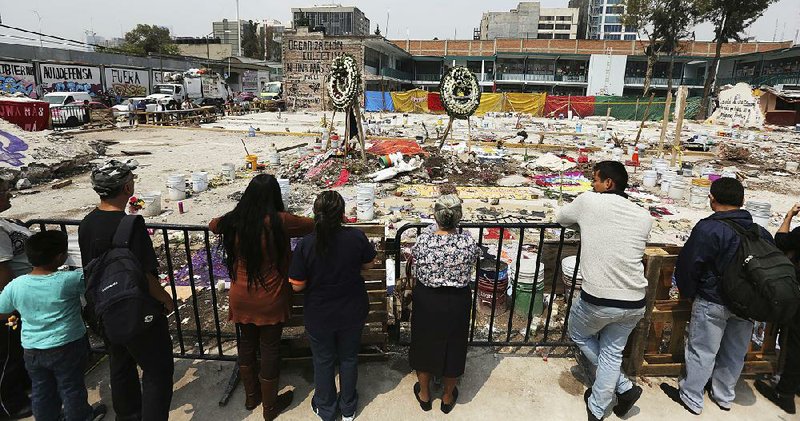 People gather Tuesday in the area where a clothing factory collapsed after an earthquake last week in Mexico City. 
