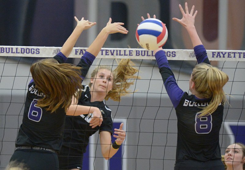 Bentonville's Savanna Riney (center) sends the ball over the net as Fayetteville's Amelia Whatley (6) and Lyndsey Mylius (8) defend Tuesday, Sept. 26, 2017, during play in Bulldog Arena in Fayetteville. Visit nwadg.com/photos to see more photographs from the match.