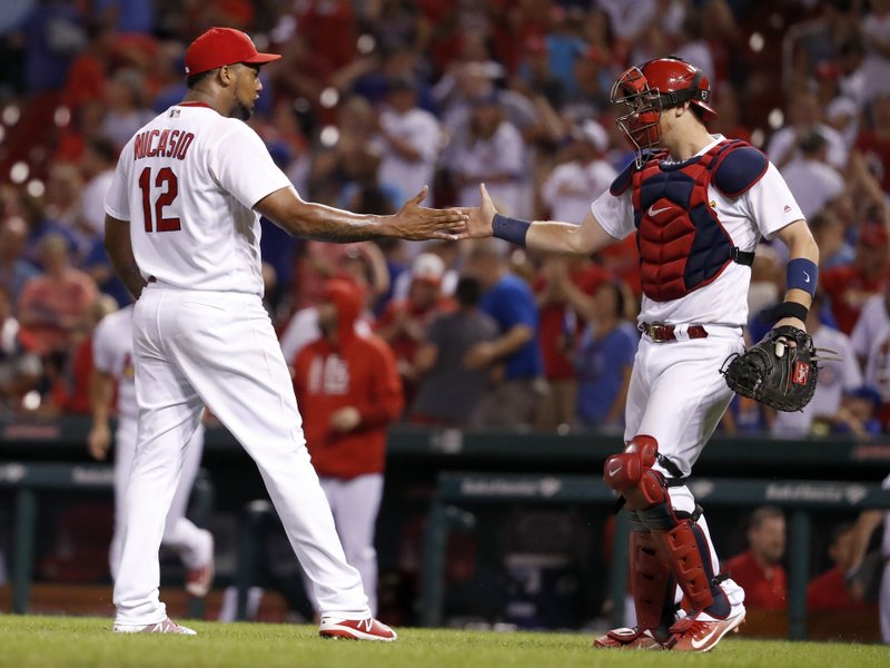 St. Louis Cardinals catcher Carson Kelly, right, and relief pitcher Juan Nicasio celebrate following the team's 8-7 victory over the Chicago Cubs in a baseball game Tuesday, Sept. 26, 2017, in St. Louis. (AP Photo/Jeff Roberson)