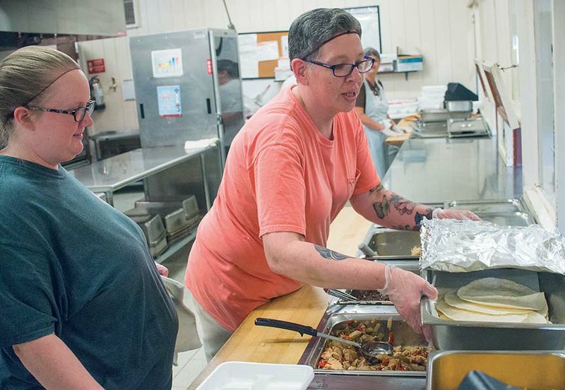 Perryville High School cafeteria employees Megan Boughton, left, and Joanne Smith work to prepare lunch one day last week. Participation in the school-lunch program has spiked since the district changed its menu after partnering with K-12 Culinary Connection, which taught the employees new recipes.