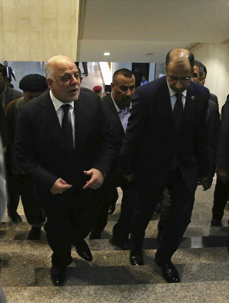 Iraqi Prime Minister Haider al-Abadi (left) arrives Wednesday for a session of the Iraqi parliament in Baghdad. Al-Abadi ordered the Kurdish region to hand over control of its airports to federal authorities or face a flight ban. 